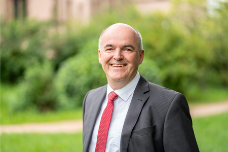 Bürgermeister Thomas Krechtler im Garten vor einem grünen Busch